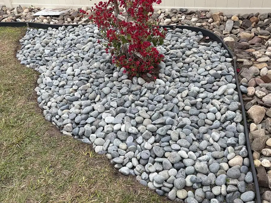 Close view of a river rock bed with contrasting stone border and edging
